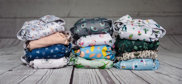 a stack of cloth diapers sitting on top of a wooden floor